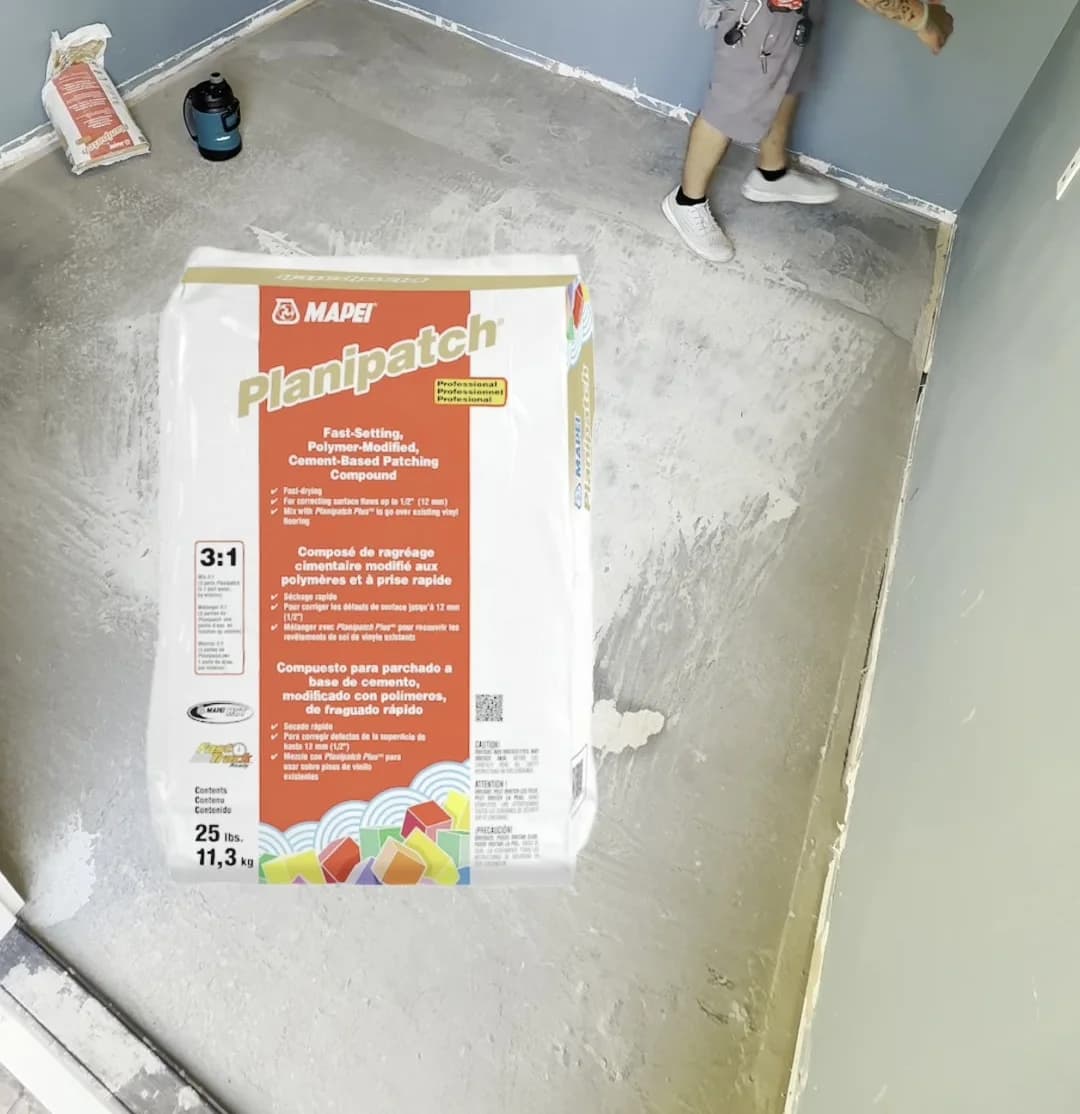 A bag of fast-setting floor patching compound standing on a freshly poured self-levelling floor
