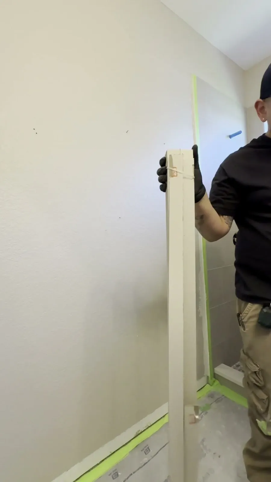 A long straightedge held against a San Antonio bathroom wall, revealing how far it bows out of plane