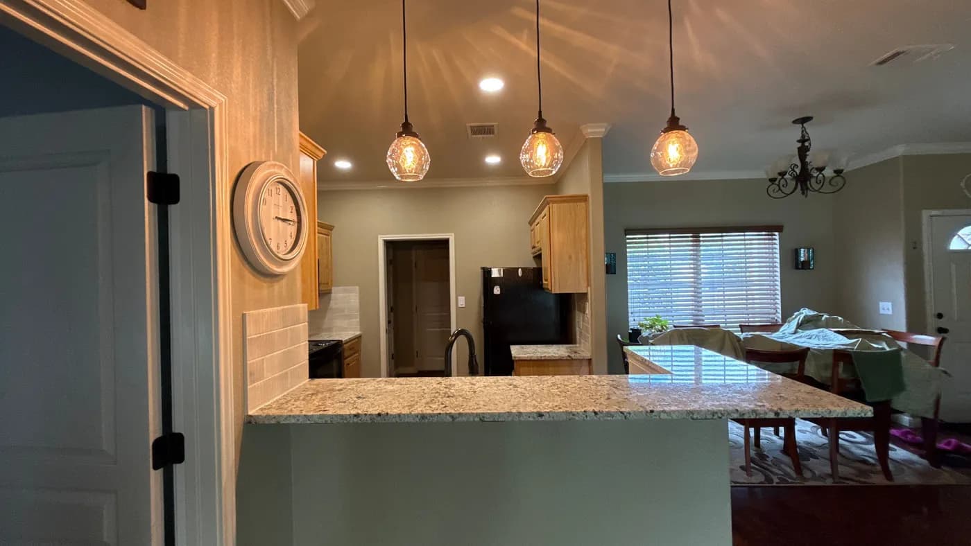 Refreshed kitchen with new countertops, pendant lighting and tiled backsplash
