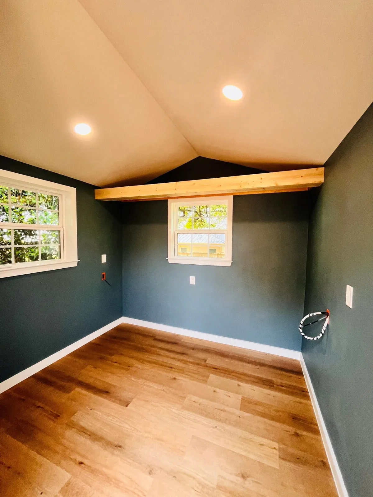 Finished studio interior with slate-blue walls, plank flooring and a vaulted ceiling