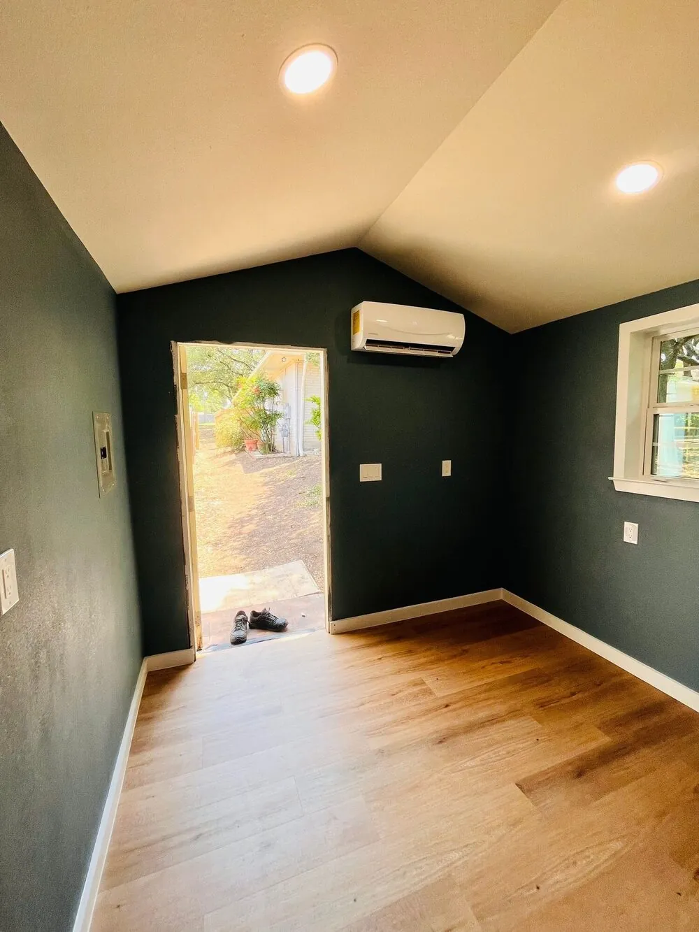Open door showing the finished interior and the yard beyond
