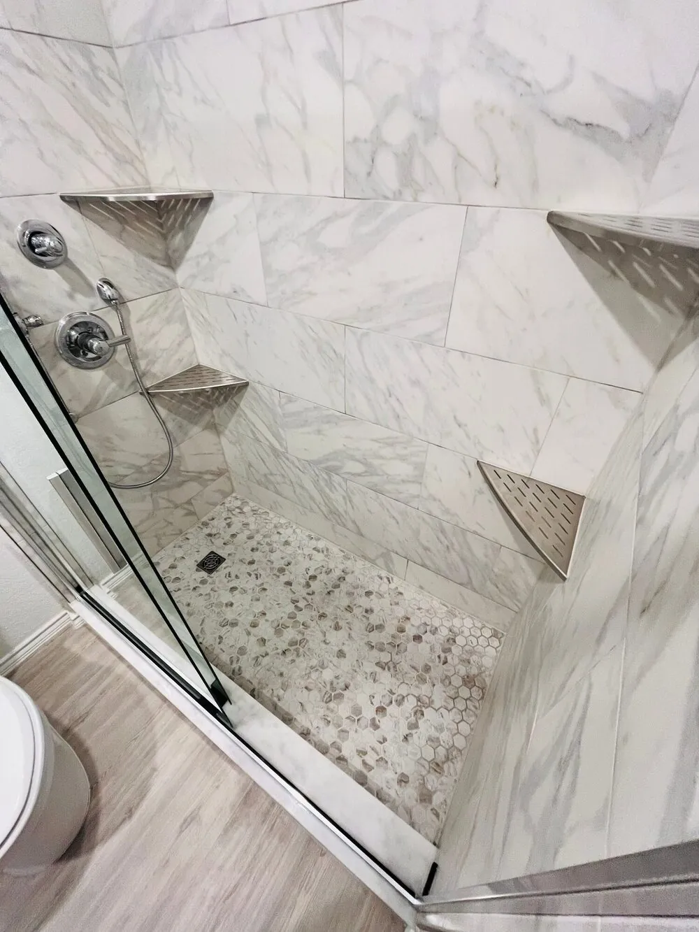 Overhead view of the finished shower with the hex mosaic floor and corner shelves