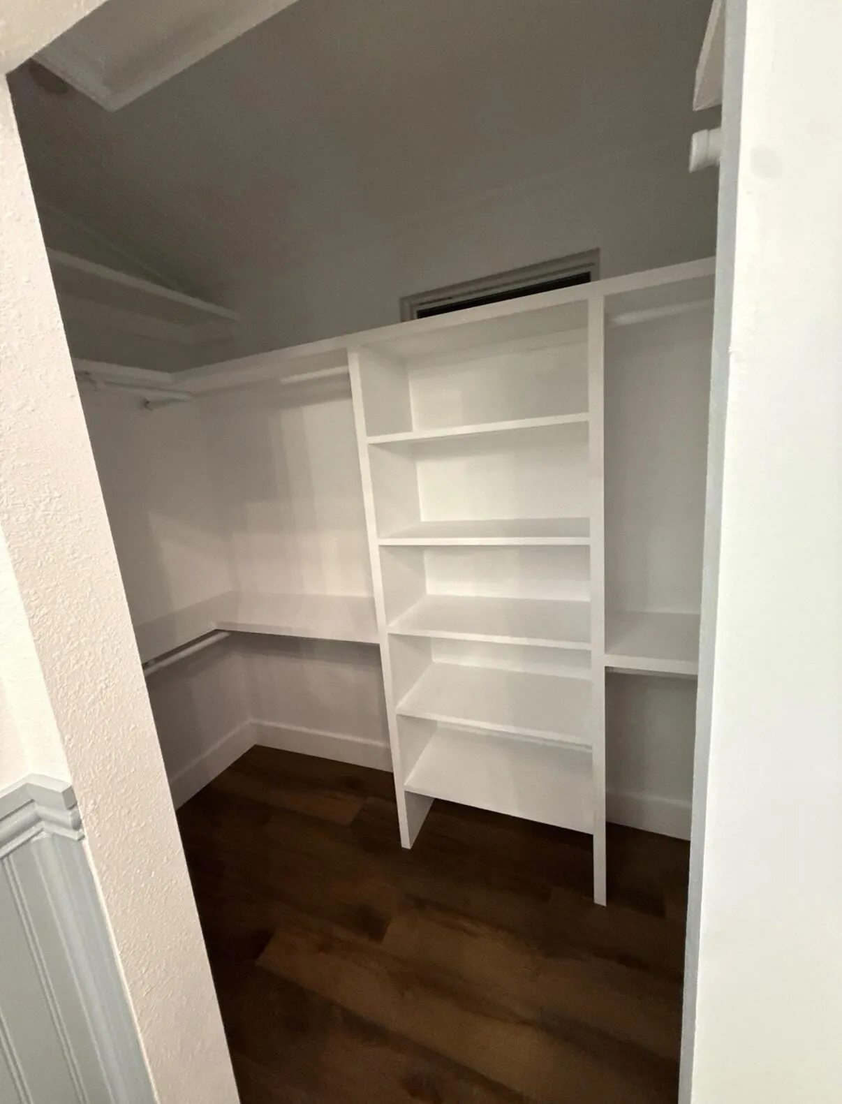 Fitted white shelving in the adjoining closet