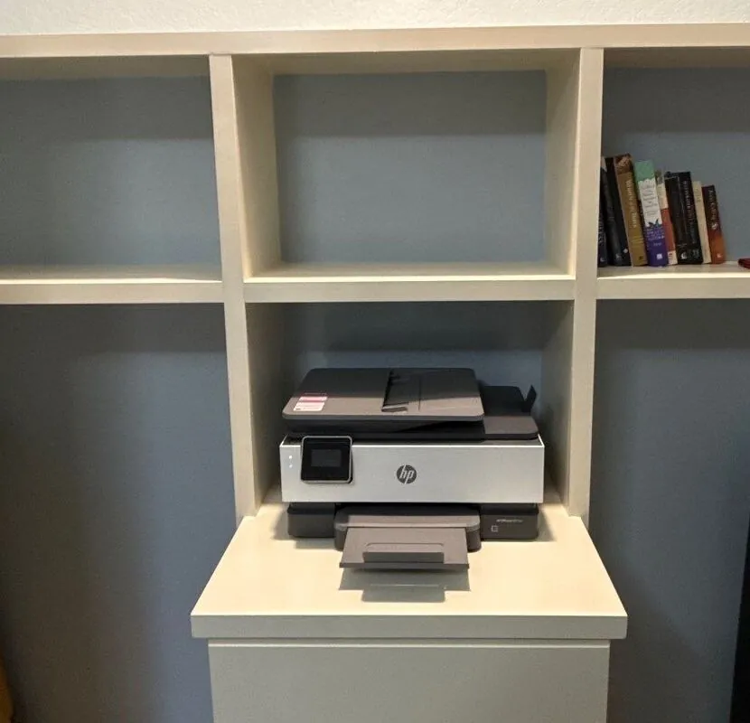 Close view of the built-in shelving grid with a printer resting on the drawer cabinet below