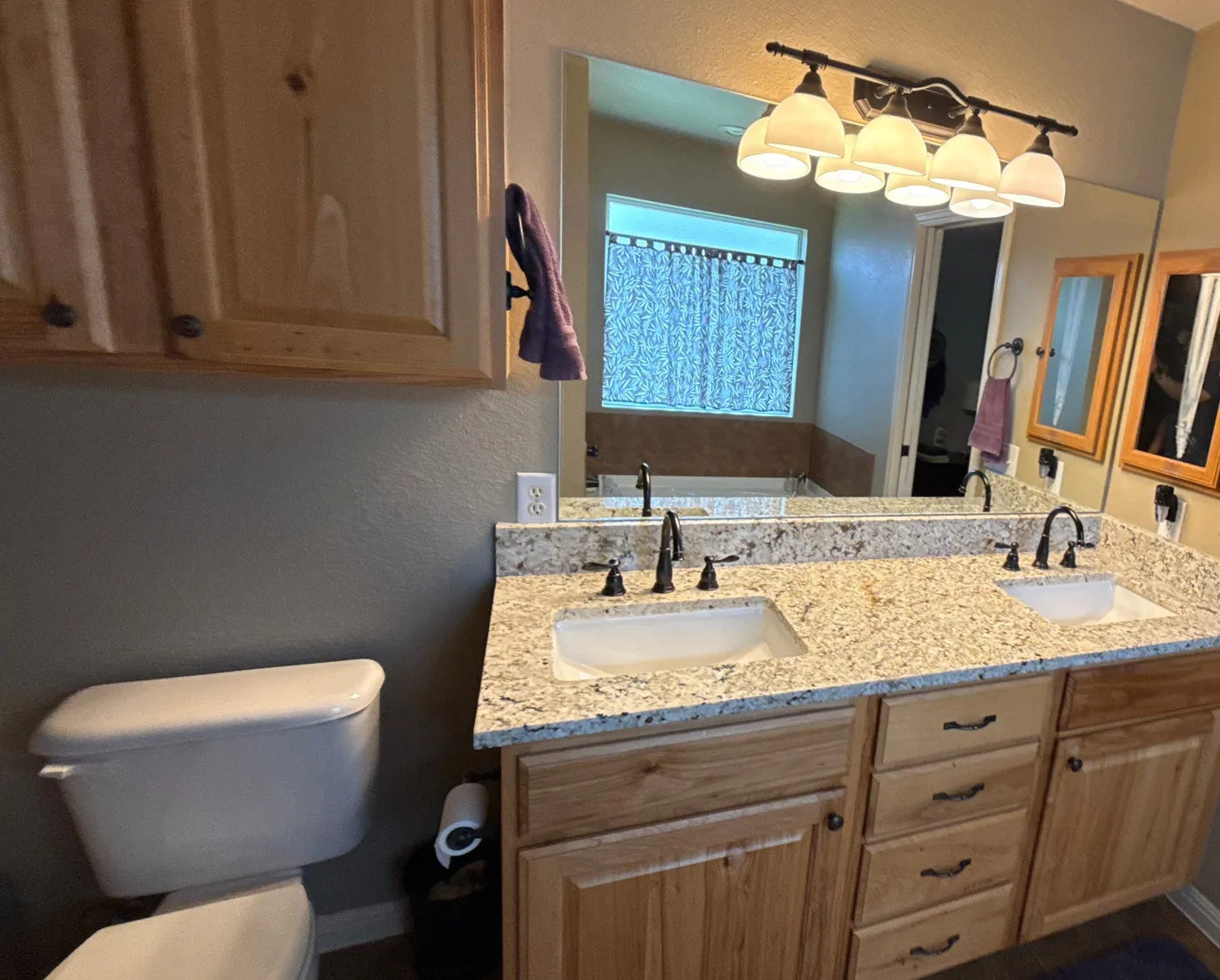 Double vanity with a new stone top, undermount sinks and dark faucets