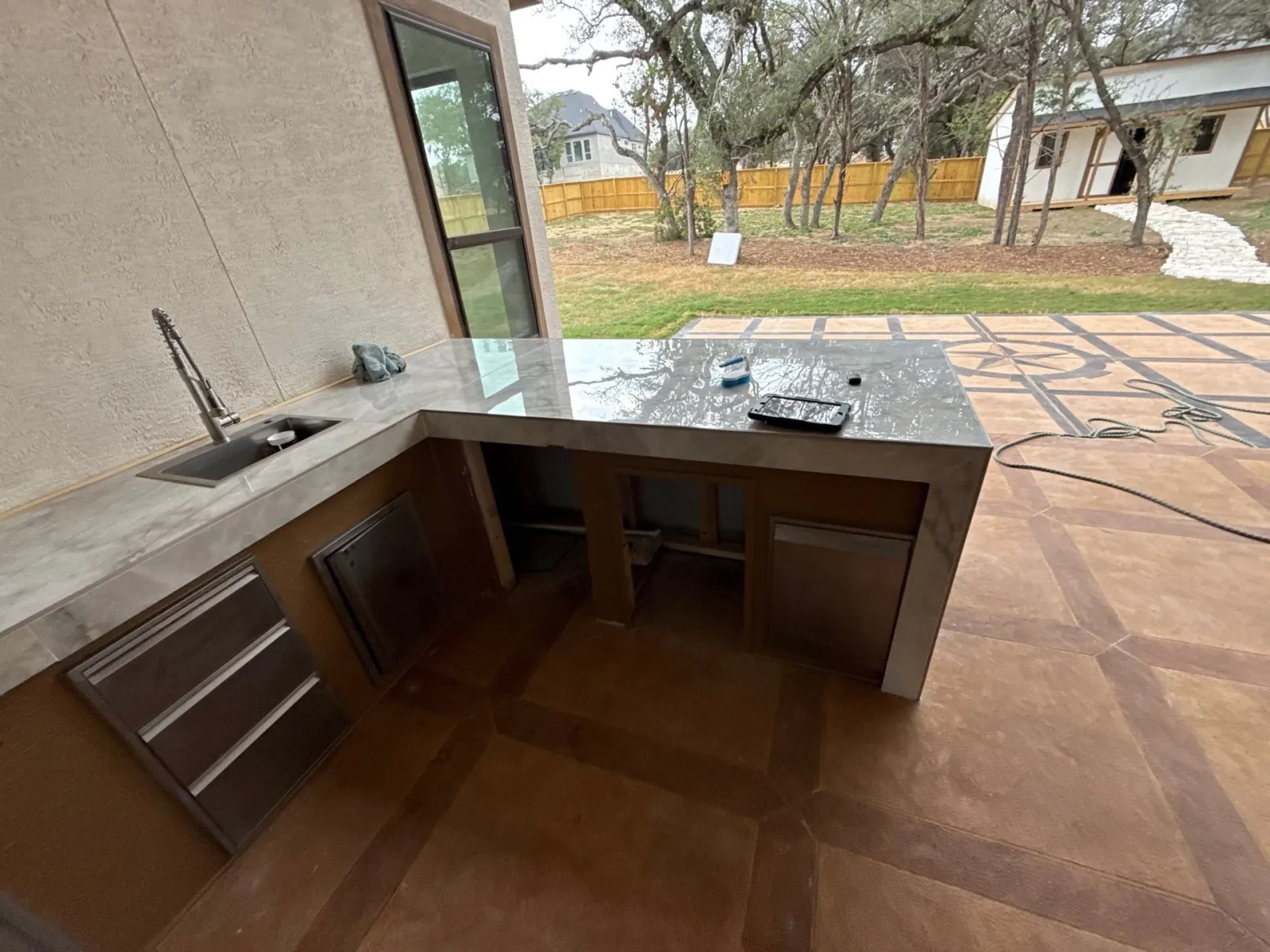 Outdoor kitchen mid-build with the stone countertop set and cabinets in place