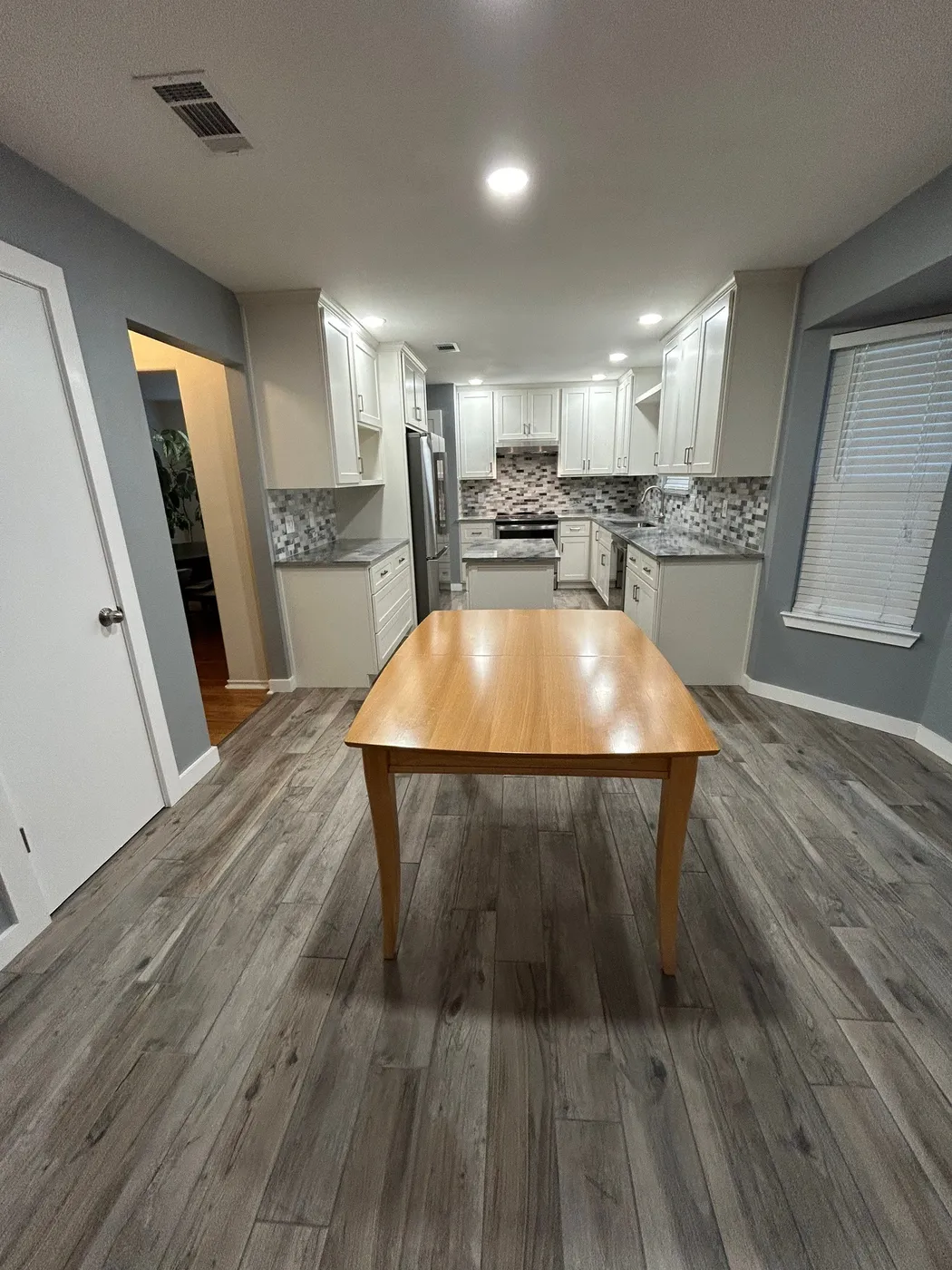 Dining area with the new wood-look flooring running toward the kitchen
