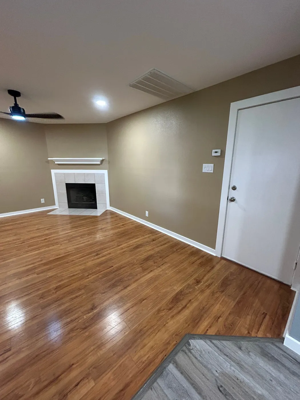 Living room corner with the fireplace beyond the flooring transition