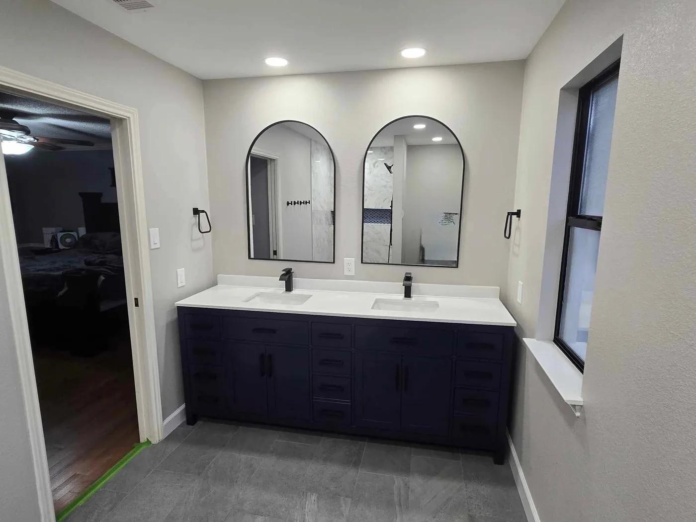 Wider view of the vanity wall with the window at right and the doorway beyond